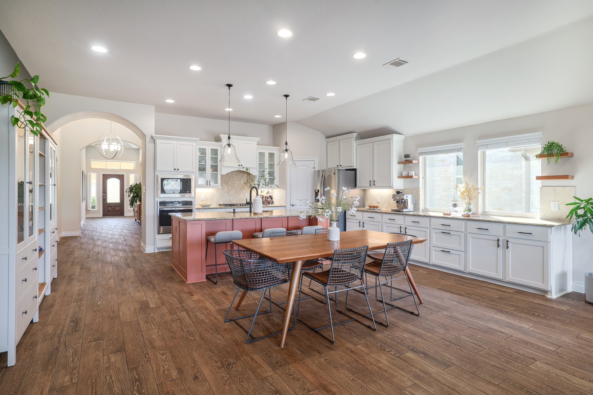 173 Santa Maria Street Georgetown, TX 78628 - Photo 16 of 39 Spacious kitchen featuring wood-finish flooring, white cabinetry, a large central island with seating, pendant lighting, and arched doorways