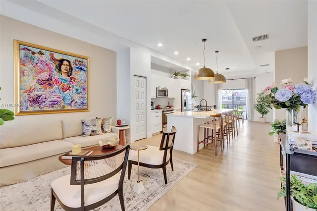 a living room with fireplace furniture and a dining table with kitchen view