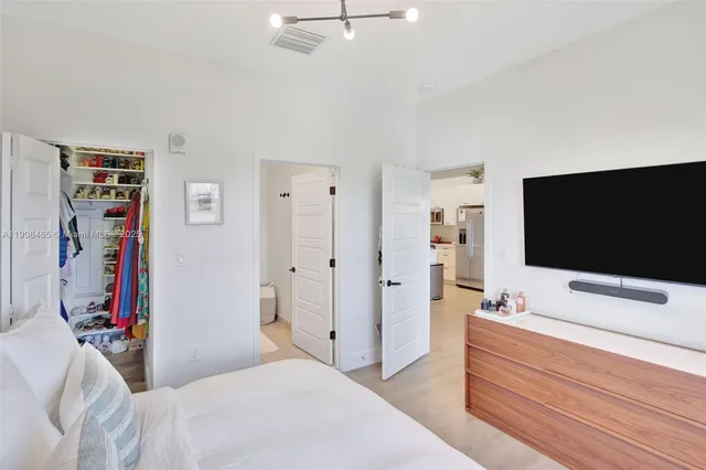 a bedroom with a bed and a flat screen tv