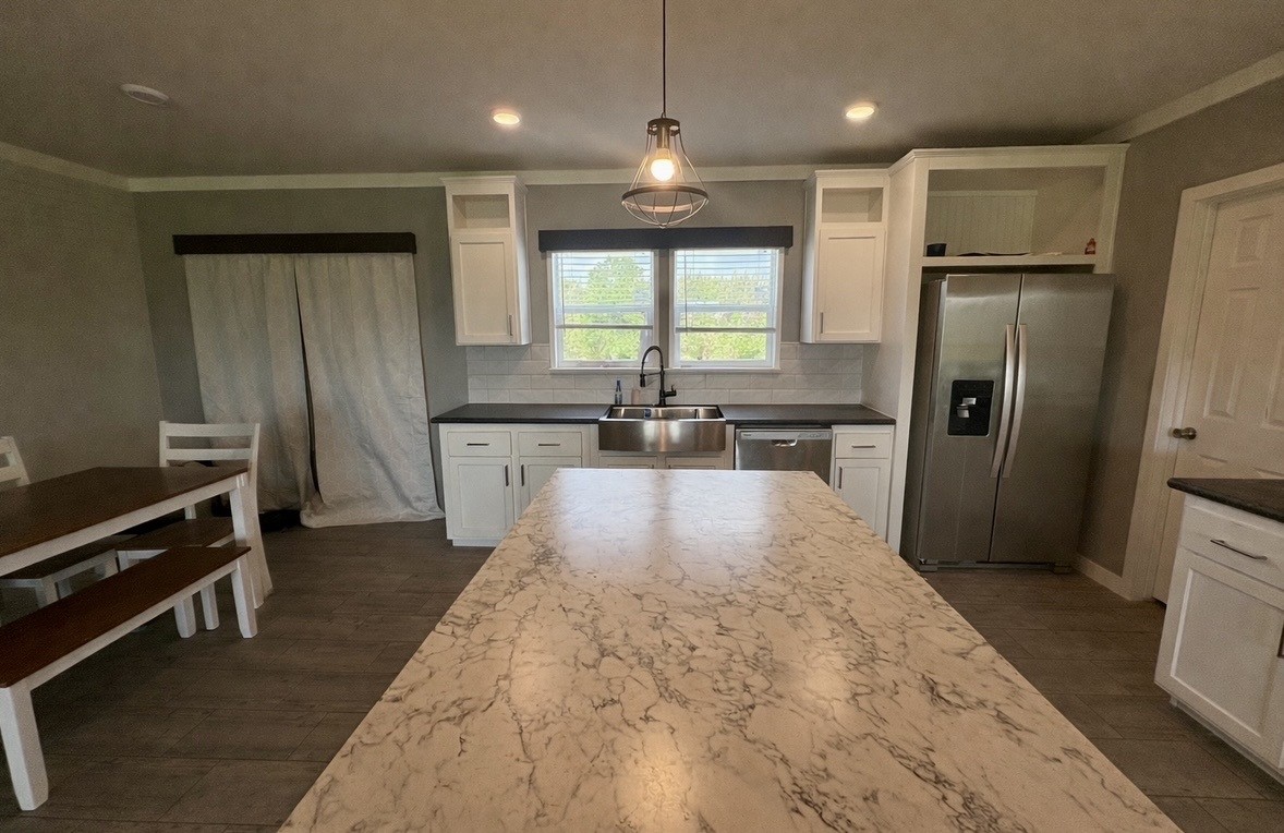 2854 Benny Griffin Road Livingston, TX 77351 - Photo 9 of 19 a large kitchen with kitchen island a refrigerator a sink dishwasher a stove and a refrigerator
