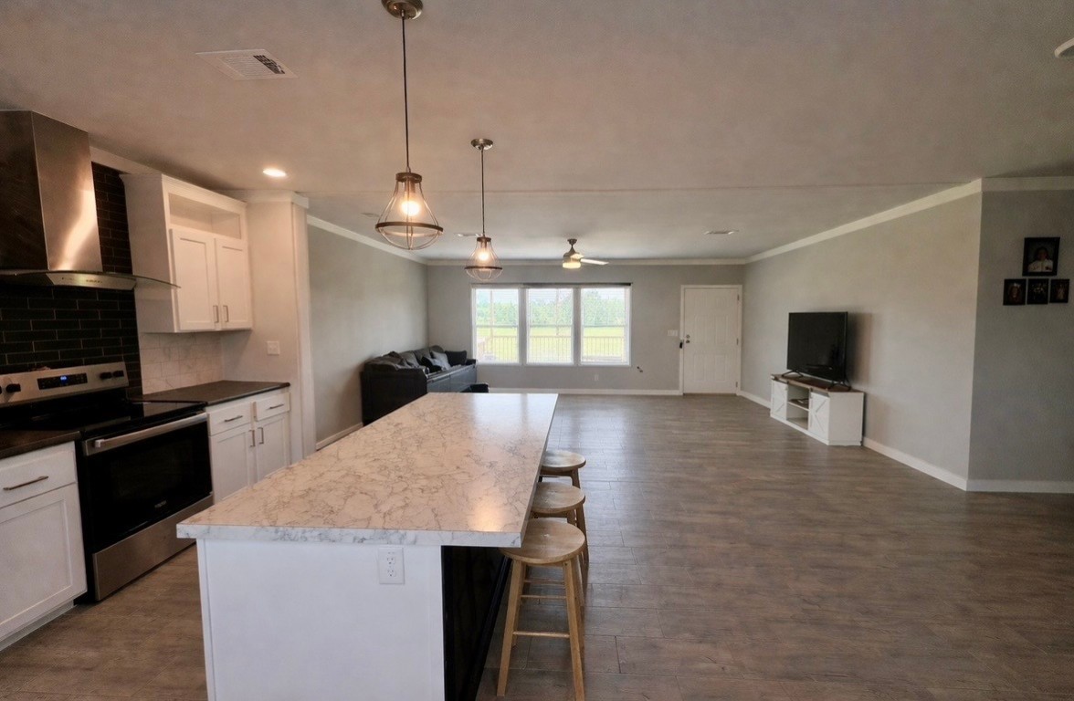 2854 Benny Griffin Road Livingston, TX 77351 - Photo 10 of 19 a large kitchen with kitchen island a stove a sink a microwave and a refrigerator