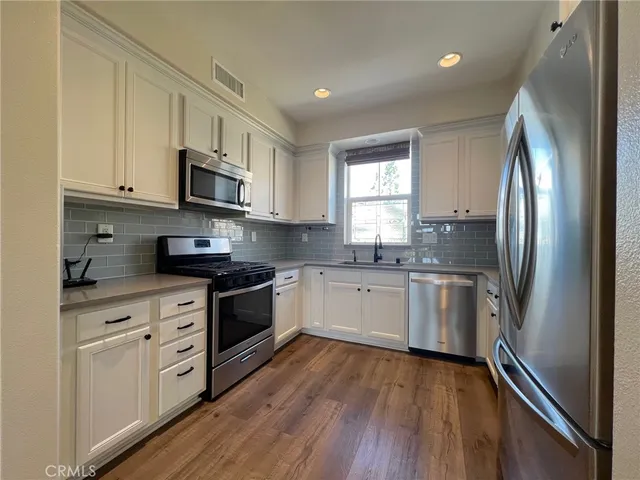 a kitchen with stainless steel appliances a refrigerator sink and microwave
