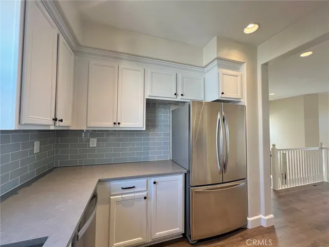 a kitchen with a refrigerator sink and cabinets
