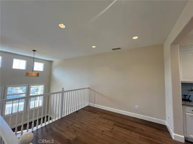 a view of hallway with wooden floor and a window