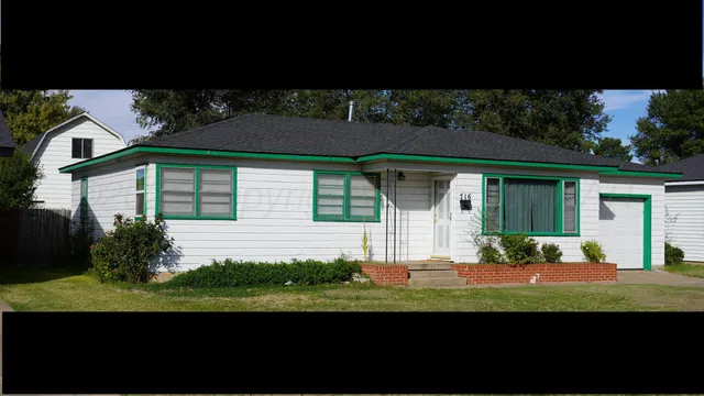 a front view of a house with a garden and plants