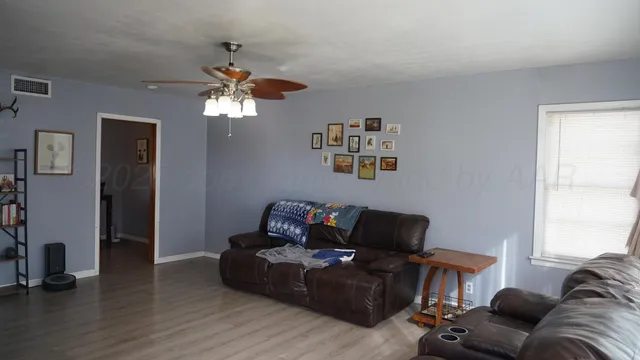 a living room with furniture and wooden floor