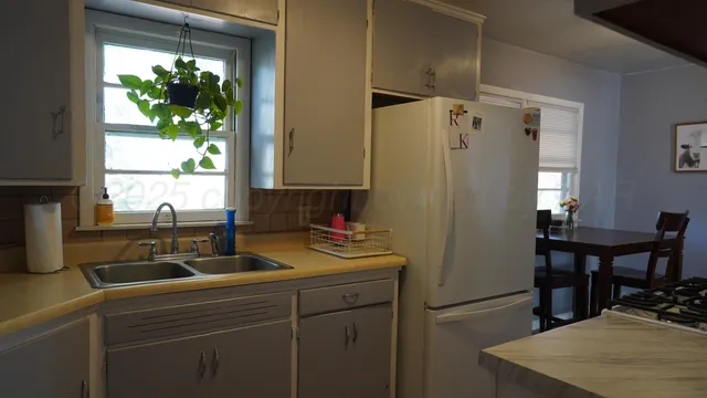 a room with a window a sink and a refrigerator