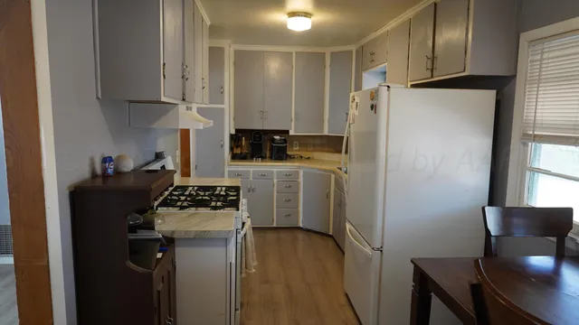 a kitchen with a refrigerator a stove a microwave and wooden floor