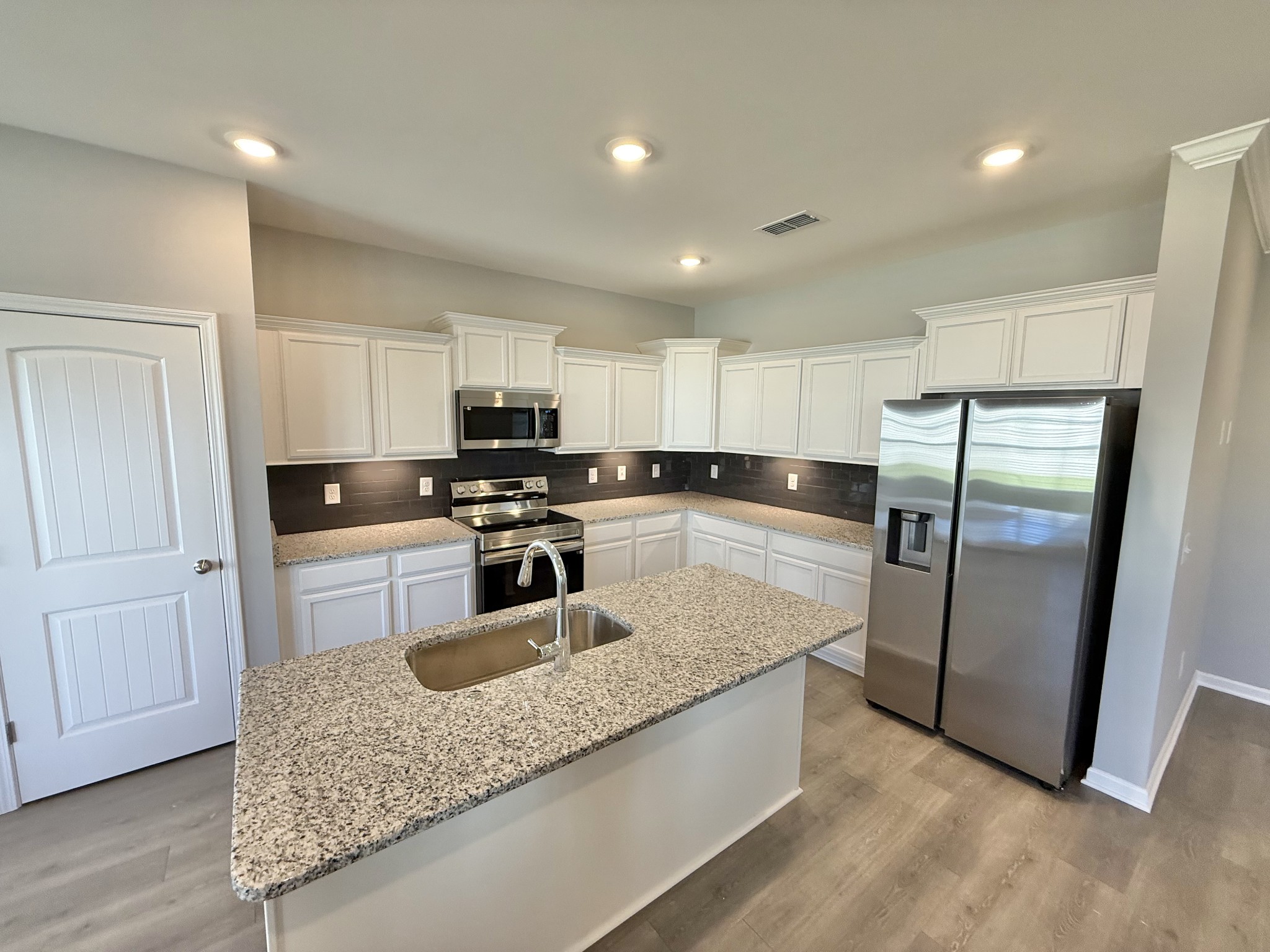 53 Ellie Jan Way Manchester, TN 37355 - Photo 3 of 11 a kitchen with granite countertop a refrigerator a sink a stove a microwave and island