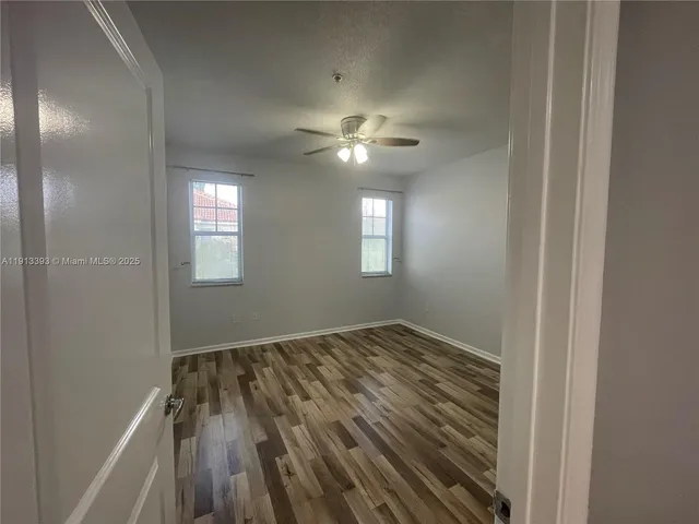 a view of empty room with window and ceiling fan