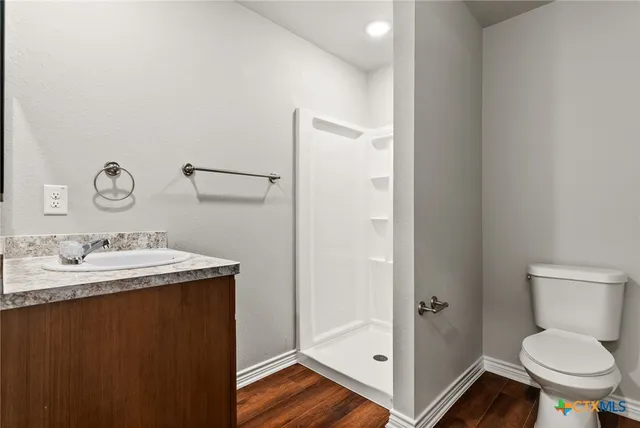 a bathroom with a granite countertop sink toilet and mirror
