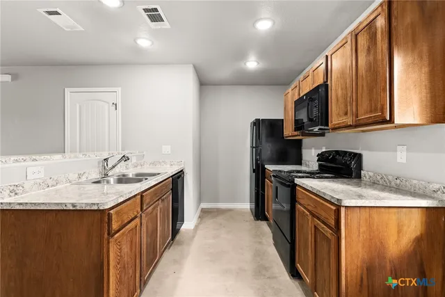 a kitchen with stainless steel appliances granite countertop a sink stove and refrigerator