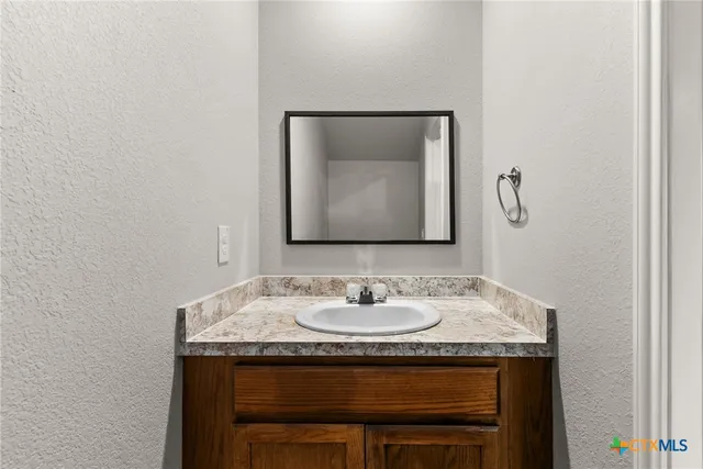 a bathroom with a granite countertop sink and a mirror