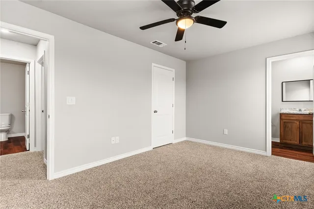 an empty room with closet and a chandelier fan