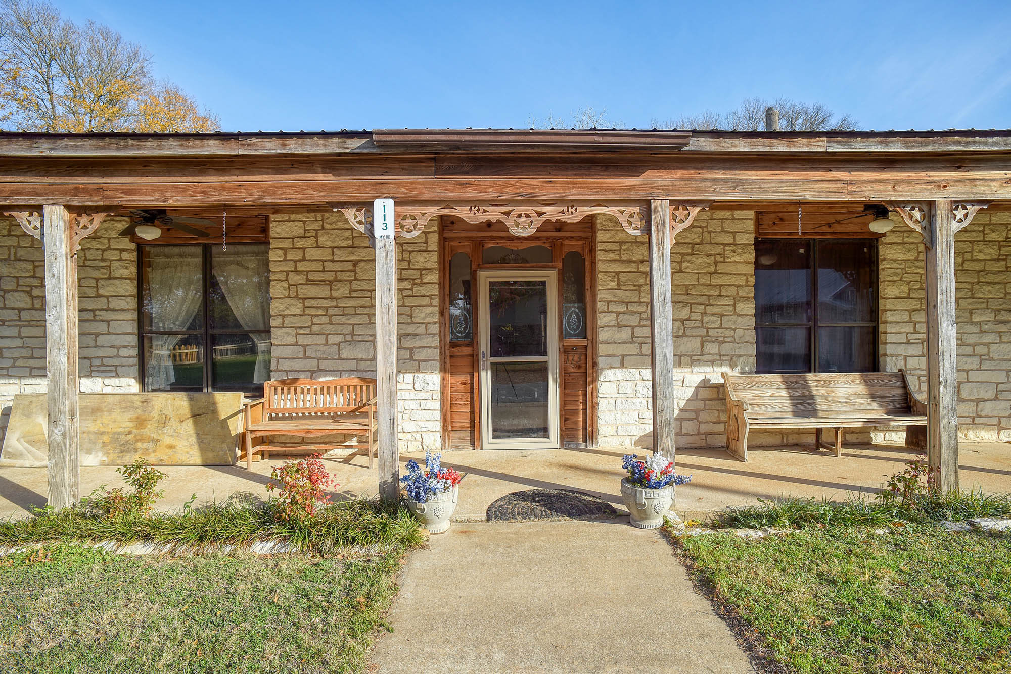 113 My Road Bastrop, TX 78602 - Photo 9 of 35 Entrance to property with stone siding, covered porch, and ceiling fan