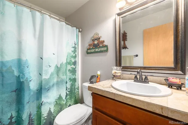 a bathroom with a granite countertop sink and a mirror with toilet