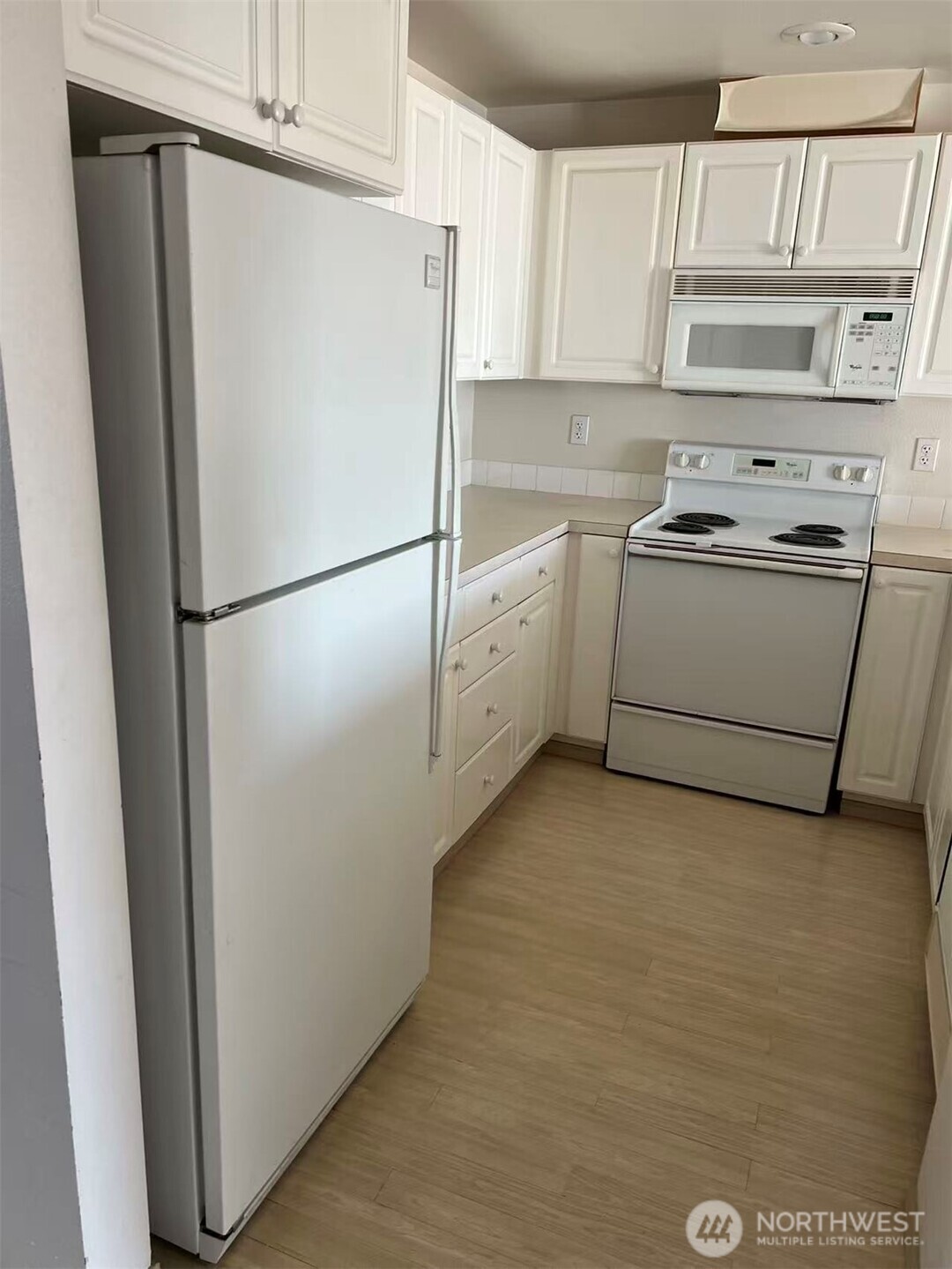 1160 Monroe Avenue Northeast, Unit D3 Renton, WA 98056 - Photo 3 of 15 a white refrigerator freezer and a stove sitting inside of a kitchen