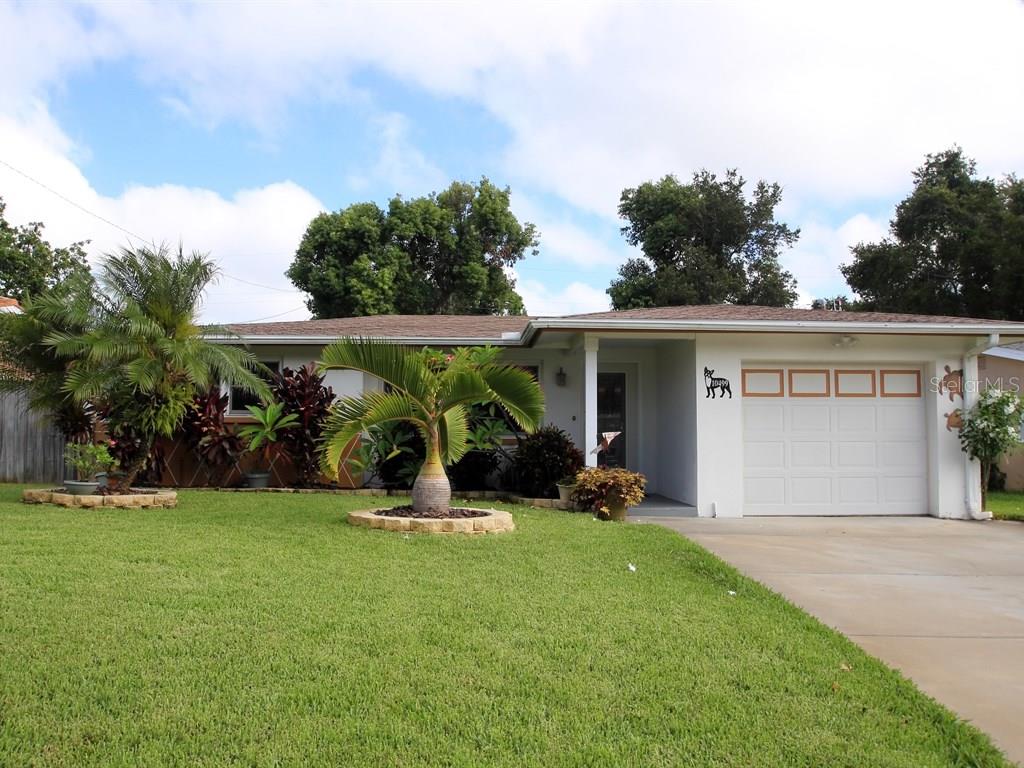 10499 Valencia Road Seminole, FL 33772 - Photo 1 of 1 front view of a house with a yard and potted plants