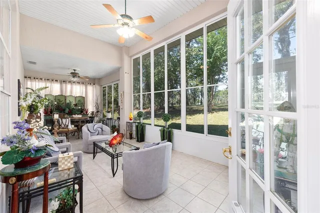a living room with furniture and floor to ceiling windows