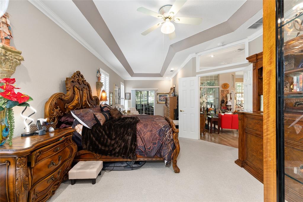 11615 Southwest 72nd Circle Ocala, FL 34476 - Photo 29 of 51 a bed room with a bed mirror and a chandelier