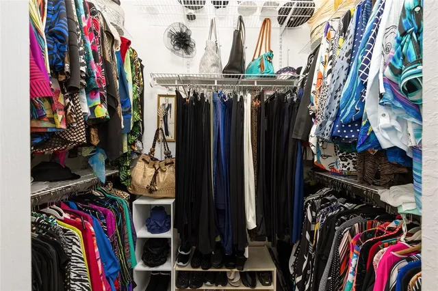 a view of walk in closet with clothes and shoes