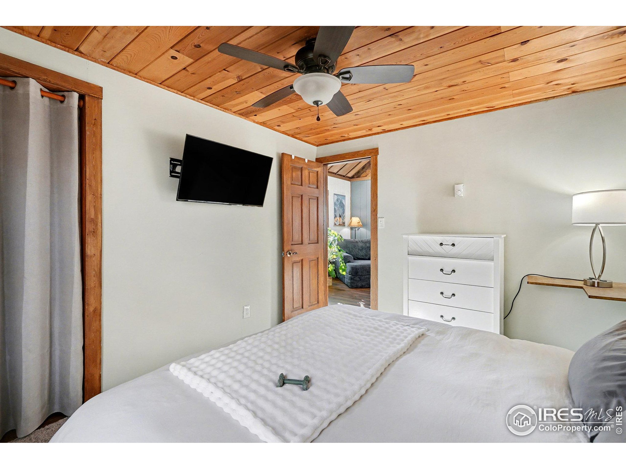 280 Streamside Drive Drake, CO 80515 - Photo 12 of 26 a bedroom with a bed and a flat screen tv