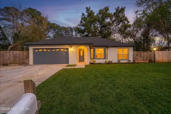 a front view of a house with a garden and yard