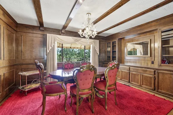 a dining room with furniture a chandelier and wooden floor