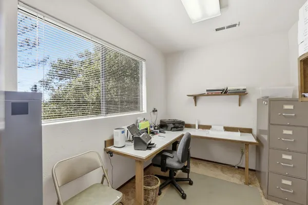 a view of a workspace with furniture and a window