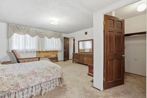 a large bedroom with a bed and a mirror
