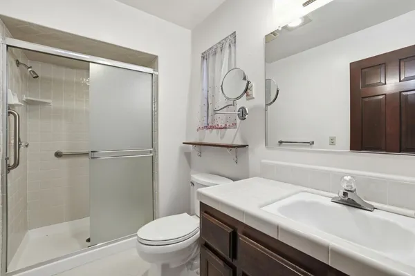 a bathroom with a granite countertop sink toilet and shower