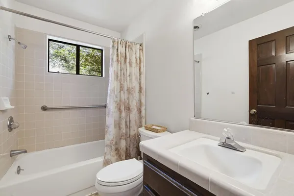 a bathroom with a sink a toilet and shower