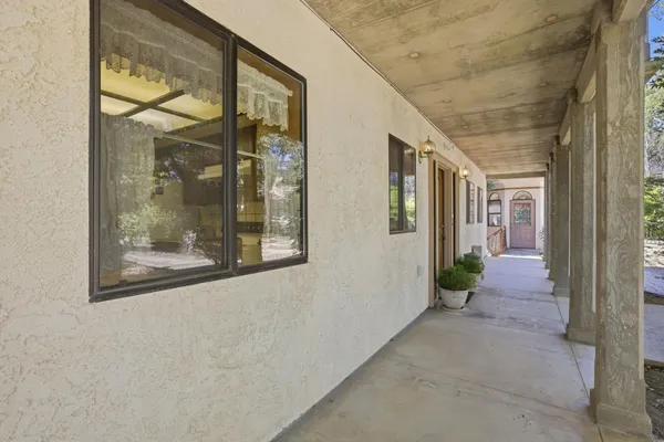 a view of a hallway with wooden floor and a living room