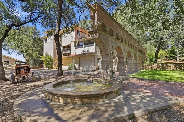 a view of a fountain with a house in the background
