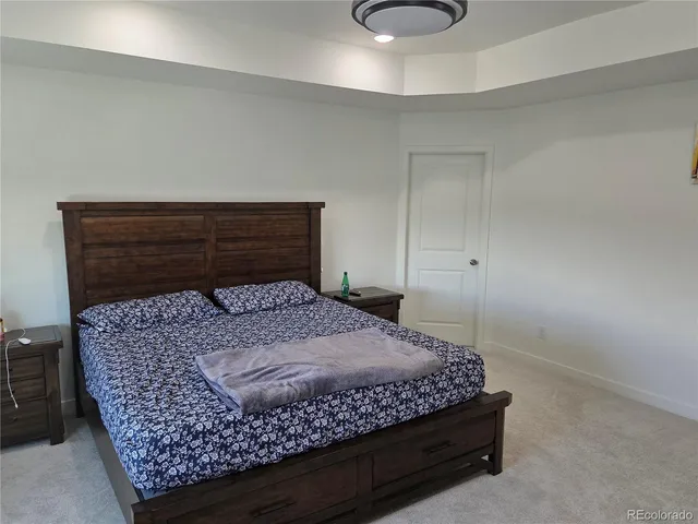 a bed sitting in a room next to a lamp