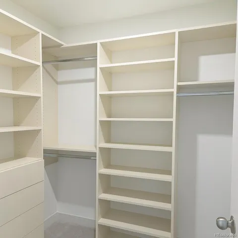 a view of walk in closet with empty racks