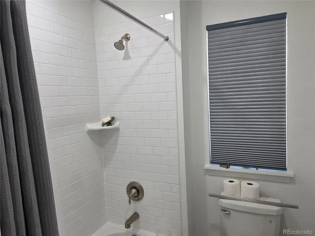 a view of a big room with wooden floor and windows