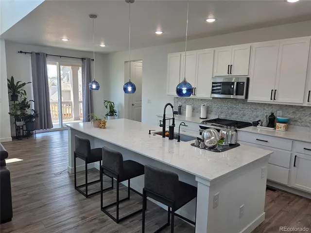a kitchen with a sink cabinets and wooden floor