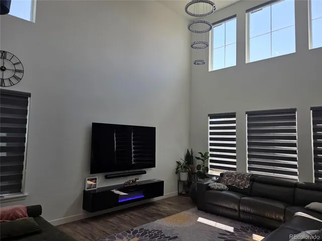 a living room with furniture a flat screen tv and a window