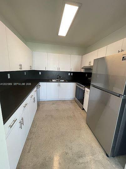 23935 Southwest 110th Court, Unit 23935 Homestead, FL 33032 - Photo 8 of 10 a kitchen with granite countertop a refrigerator and a sink