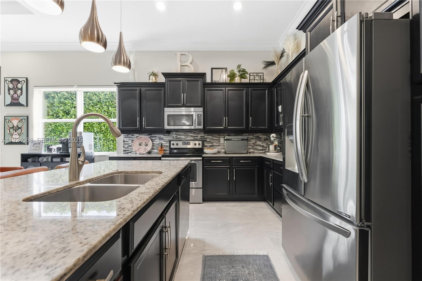 14929 Southwest 176th Terrace Miami, FL 33187 - Photo 11 of 38 a kitchen with kitchen island granite countertop a sink stove and refrigerator