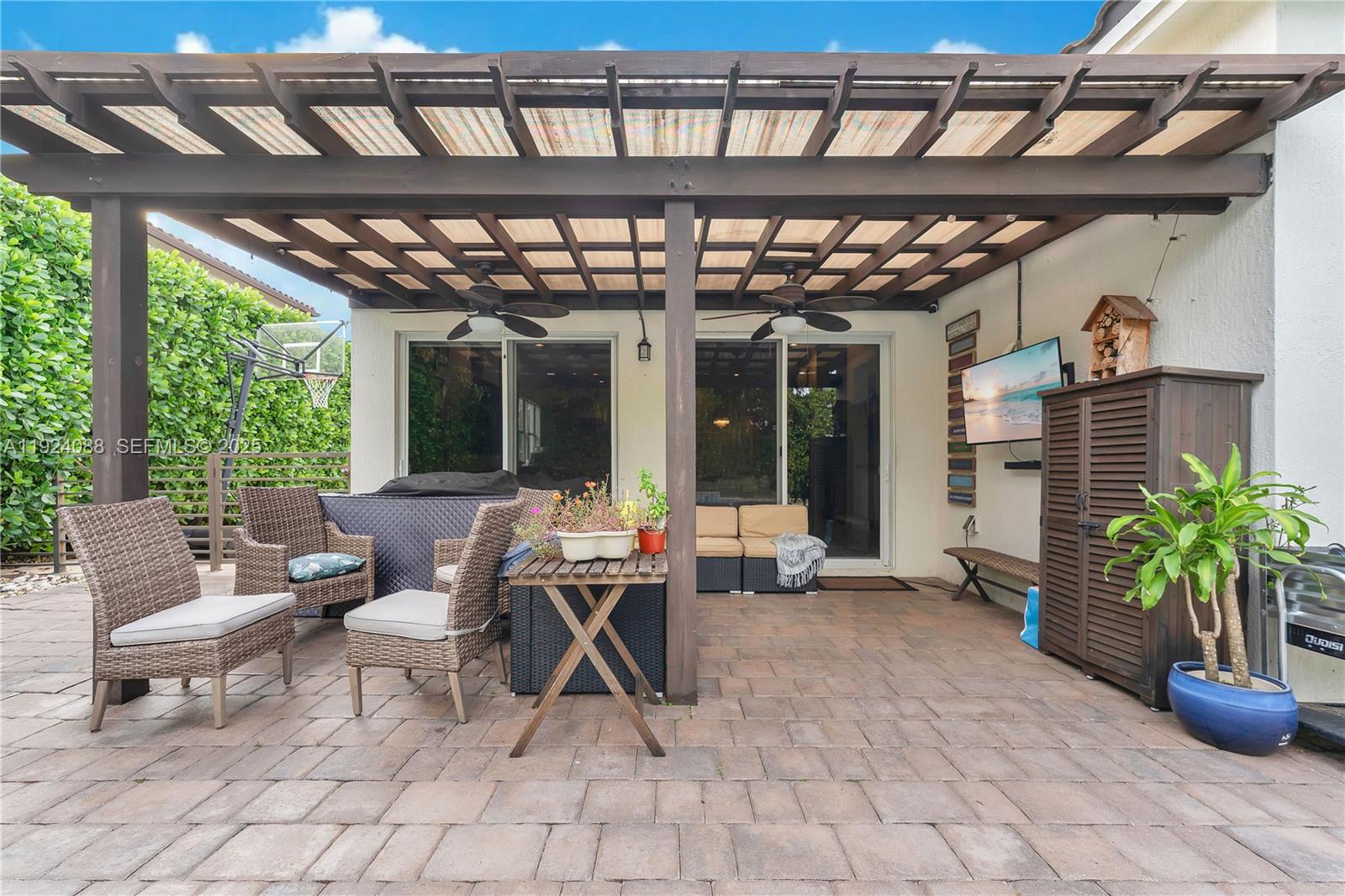 14929 Southwest 176th Terrace Miami, FL 33187 - Photo 29 of 38 a view of a patio with table and chairs potted plants and floor to ceiling window