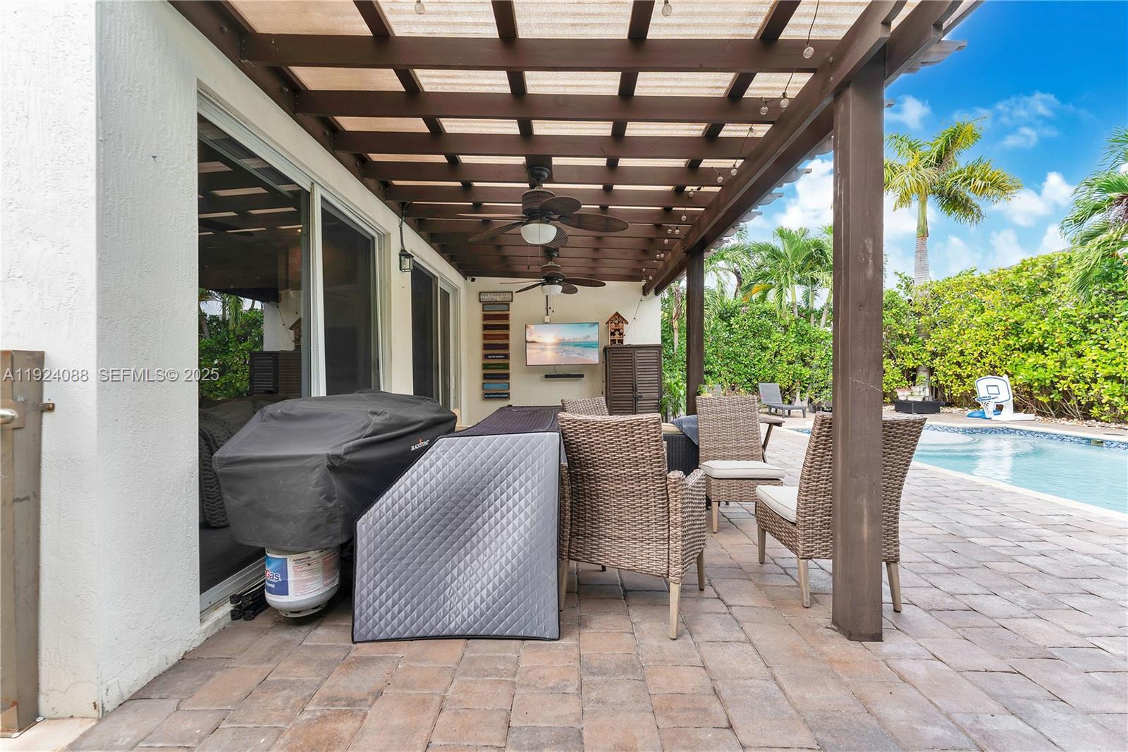 14929 Southwest 176th Terrace Miami, FL 33187 - Photo 30 of 38 a view of a patio with table and chairs potted plants and floor to ceiling window