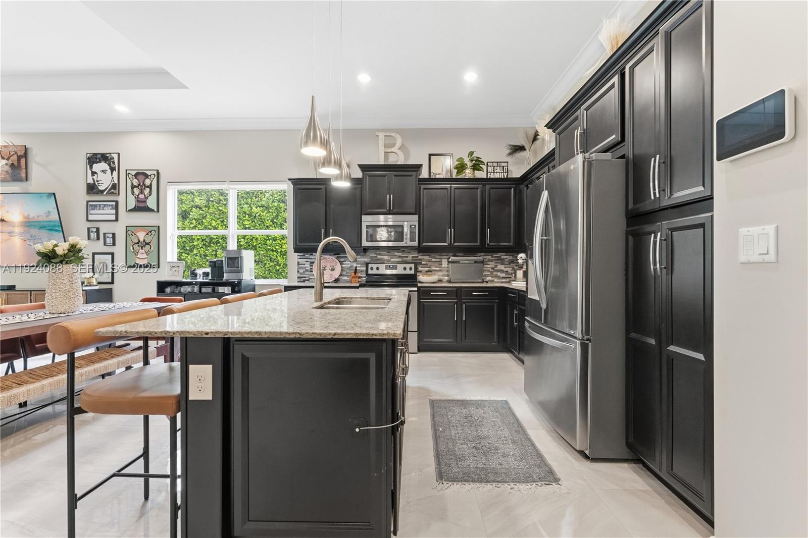 14929 Southwest 176th Terrace Miami, FL 33187 - Photo 10 of 38 a kitchen with stainless steel appliances kitchen island granite countertop a refrigerator and a sink