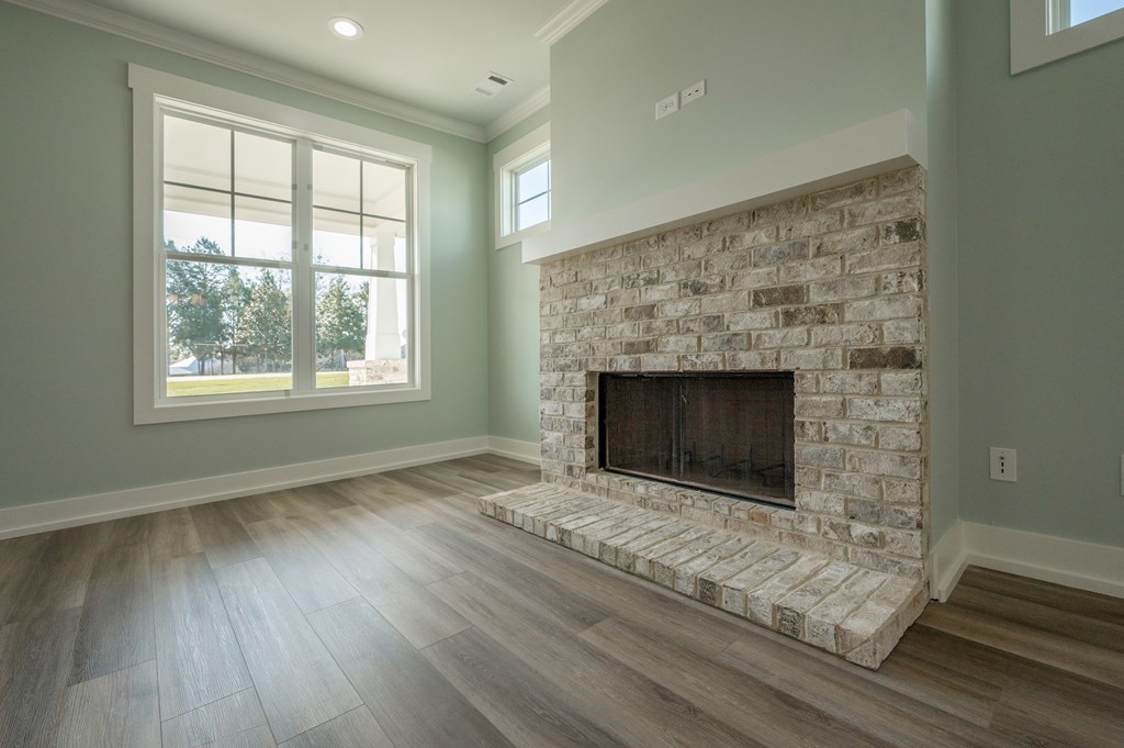 1190 Lee Road Phenix City, AL 36870 - Photo 11 of 52 an empty room with wooden floor fireplace and windows