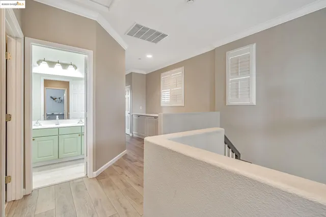 a view of a hallway with wooden floor and a living room