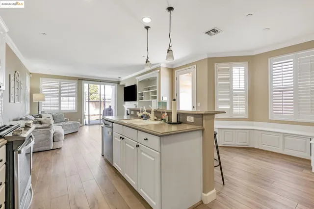 a large kitchen with kitchen island lots of counter space a sink appliances and a large window