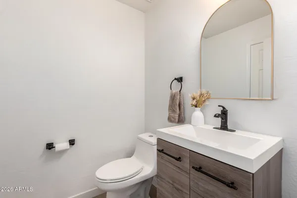 a bathroom with a sink a toilet and mirror