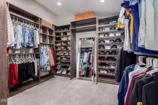 a view of walk in closet with clothes and shoes