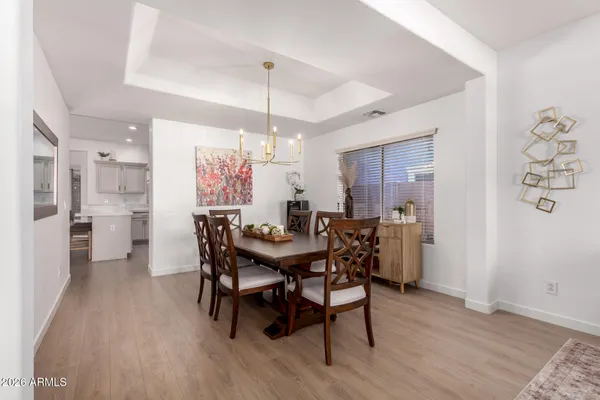 a view of a dining room and livingroom with furniture wooden floor a rug a chandelier